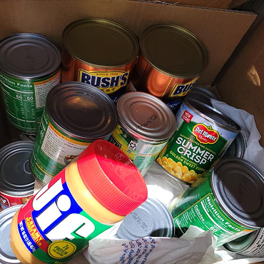 A box of canned food ready to be distributed to help those in need of food assistance